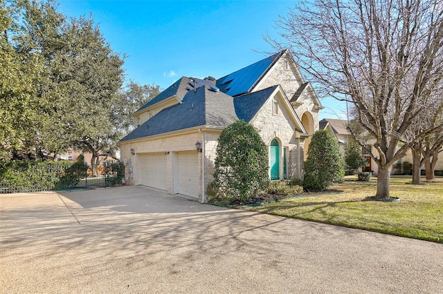 4514 Harvey Penick Dr, Round Rock, TX 78664 - view of home's exterior with stone siding, concrete driveway, an attached garage, and a chimney