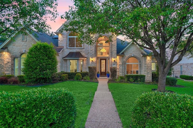 view of front facade featuring stone siding and a front lawn