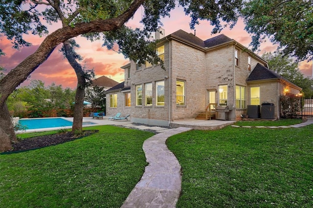 4514 Harvey Penick Dr, Round Rock, TX 78664 - back of property at dusk featuring stone siding, a patio, and a fenced backyard