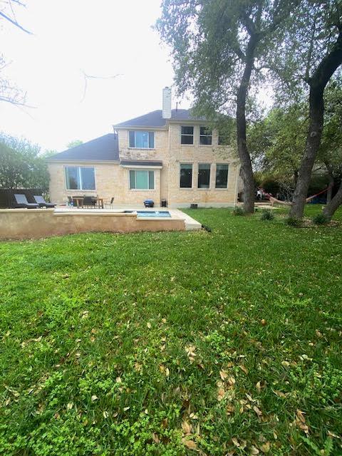rear view of house with a lawn and a chimney