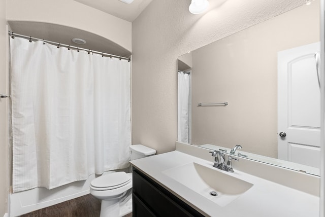 397 Arapaho Dr, Kyle, TX 78640 - full bathroom featuring vanity, wood finished floors, shower / bath combo, toilet, and a textured wall