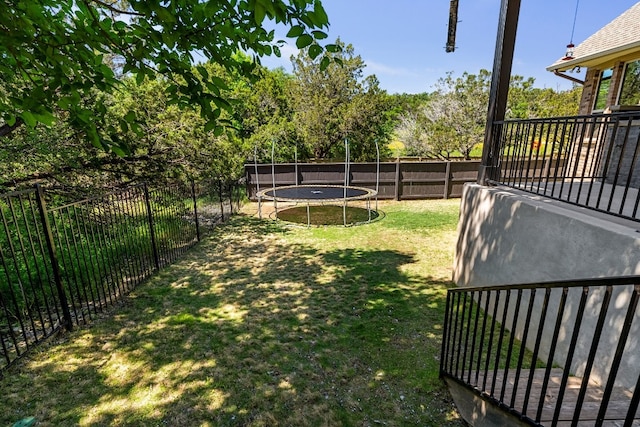 397 Arapaho Dr, Kyle, TX 78640 - view of yard featuring a trampoline and a fenced backyard