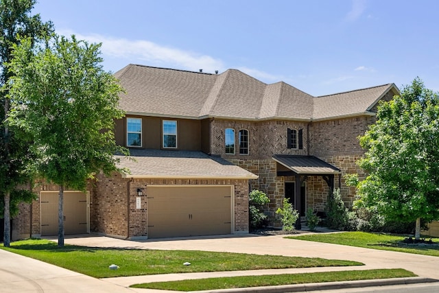 french country home with brick siding, a shingled roof, a front lawn, concrete driveway, and an attached garage