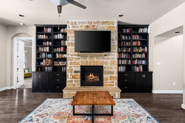 397 Arapaho Dr, Kyle, TX 78640 - living room featuring a fireplace, a textured ceiling, baseboards, and wood finished floors