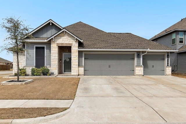 view of front of home with driveway, stone siding, board and batten siding, roof with shingles, and an attached garage