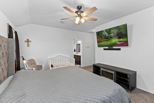 carpeted bedroom featuring visible vents, connected bathroom, a ceiling fan, and vaulted ceiling