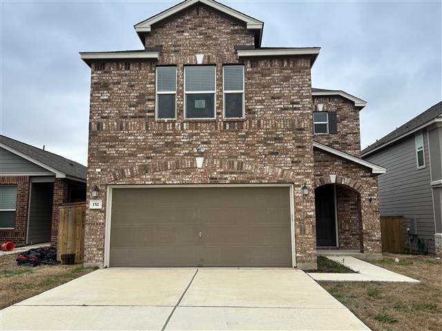 view of front of house featuring brick siding, concrete driveway, and an attached garage