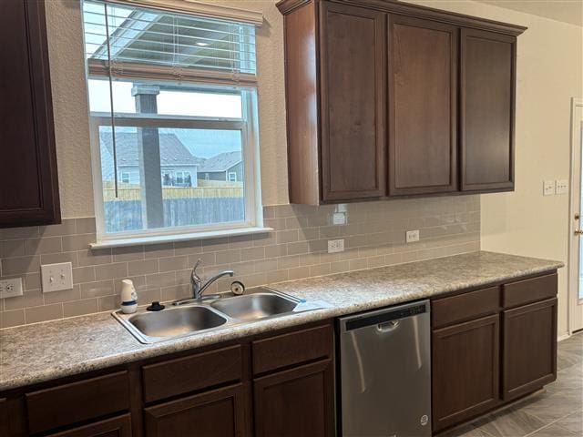 kitchen featuring a sink, decorative backsplash, light countertops, dark brown cabinetry, and dishwasher