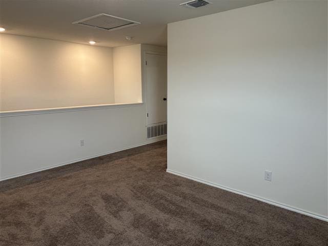 spare room featuring attic access, carpet flooring, baseboards, and visible vents