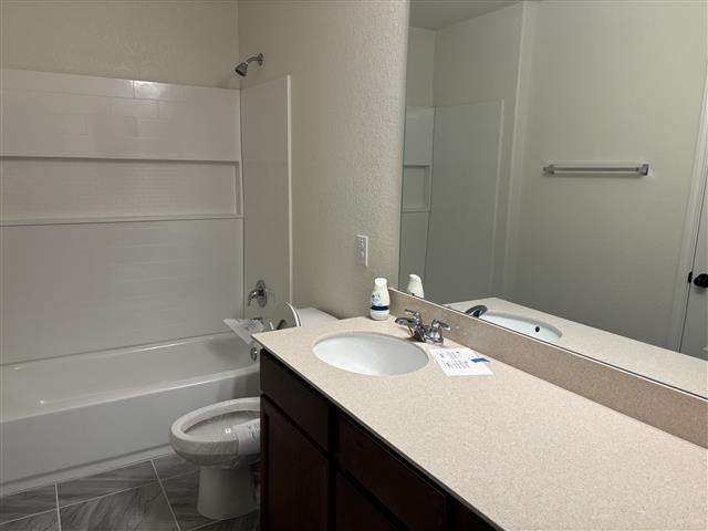 bathroom featuring vanity, toilet, and bathing tub / shower combination