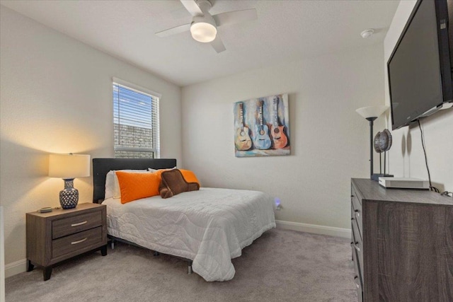 bedroom featuring light colored carpet, a ceiling fan, and baseboards