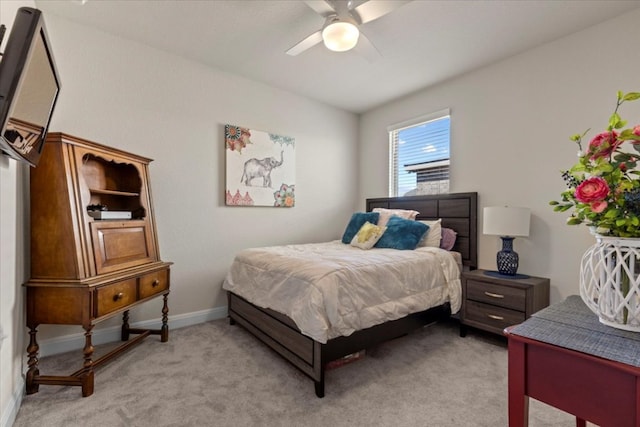 bedroom featuring light carpet, a ceiling fan, and baseboards