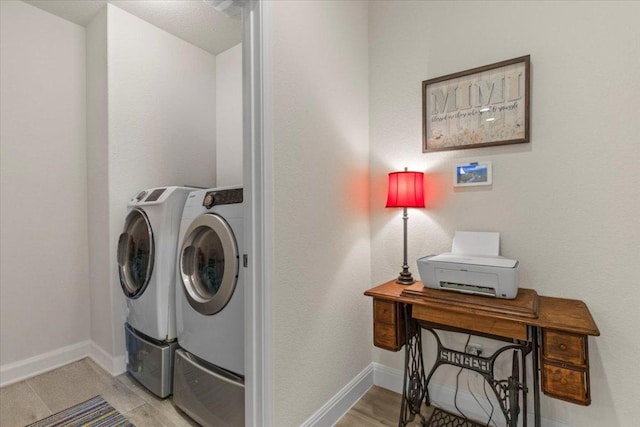 laundry area featuring baseboards, independent washer and dryer, laundry area, and light wood finished floors