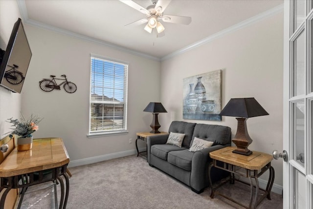 sitting room with ceiling fan, baseboards, carpet, and ornamental molding