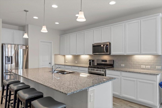 kitchen featuring a sink, stainless steel appliances, a kitchen breakfast bar, and backsplash