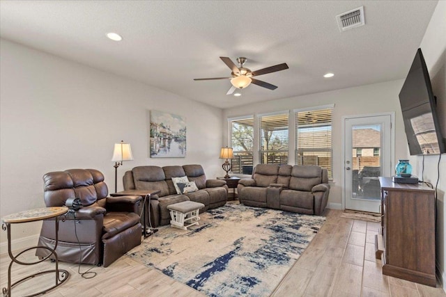 living area with a ceiling fan, recessed lighting, light wood-style floors, and visible vents