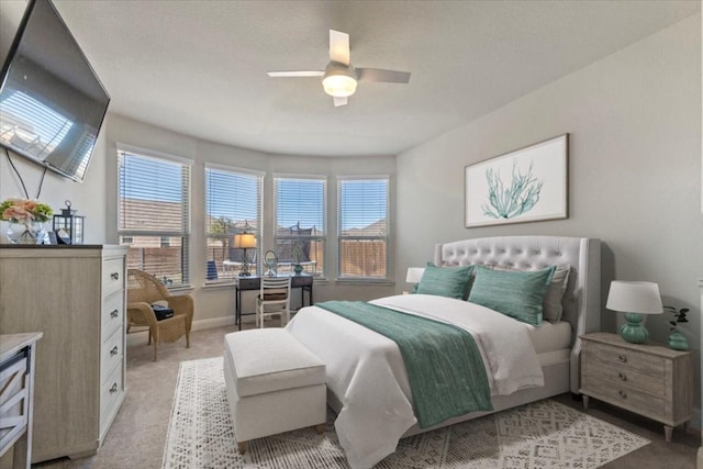 bedroom with light carpet, ceiling fan, and baseboards