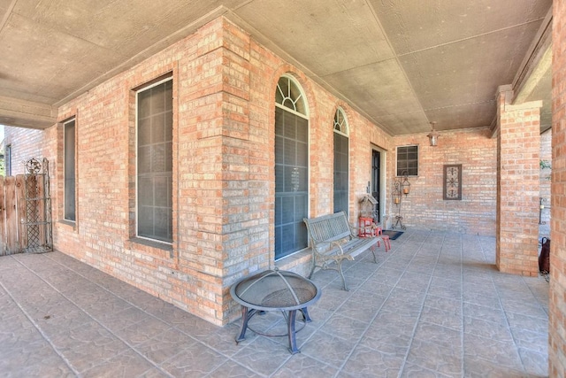 view of patio with a porch and an outdoor fire pit