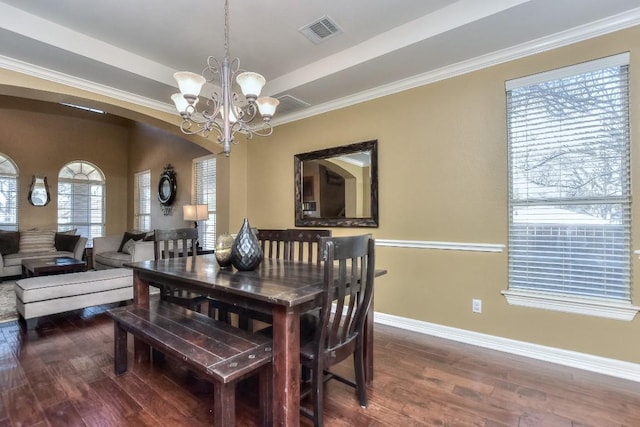 dining space featuring visible vents, a tray ceiling, wood finished floors, an inviting chandelier, and baseboards