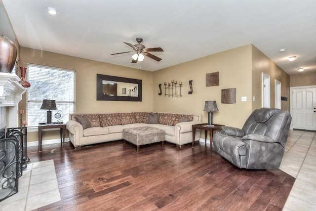 living area featuring ceiling fan, baseboards, and wood finished floors