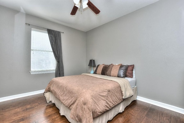 bedroom with dark wood-style floors, baseboards, and ceiling fan