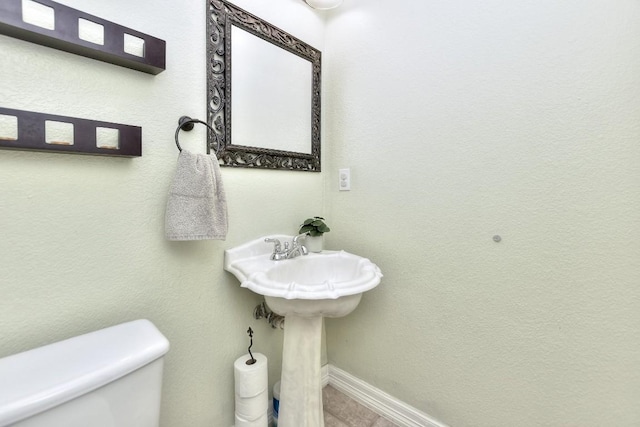 bathroom featuring toilet and baseboards