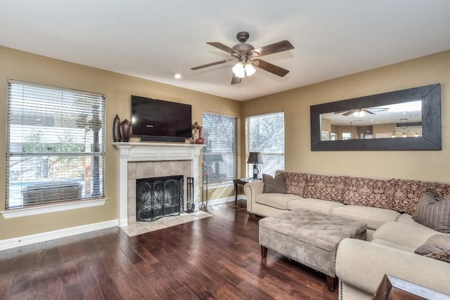 living area featuring ceiling fan, wood finished floors, baseboards, and a tile fireplace