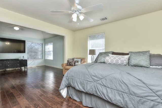 bedroom with visible vents, multiple windows, baseboards, and wood finished floors