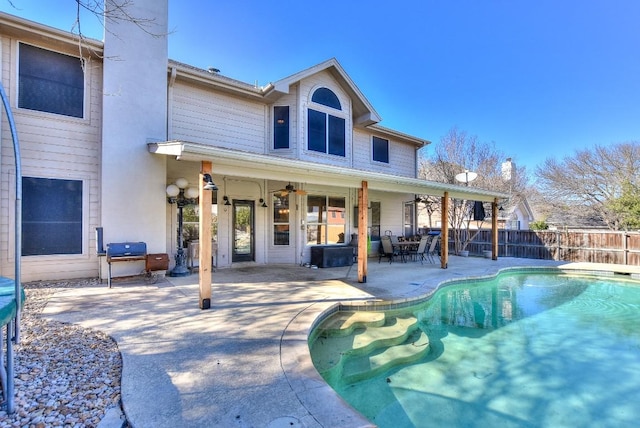 rear view of house featuring a fenced in pool, ceiling fan, a patio, and fence