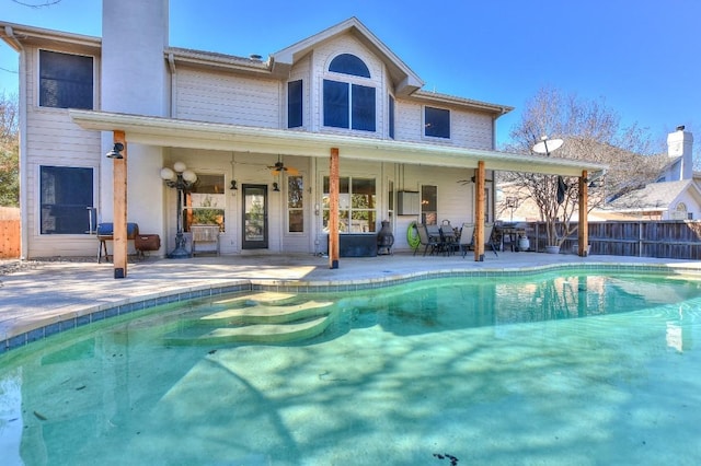 back of property featuring a fenced in pool, a patio area, fence, and ceiling fan