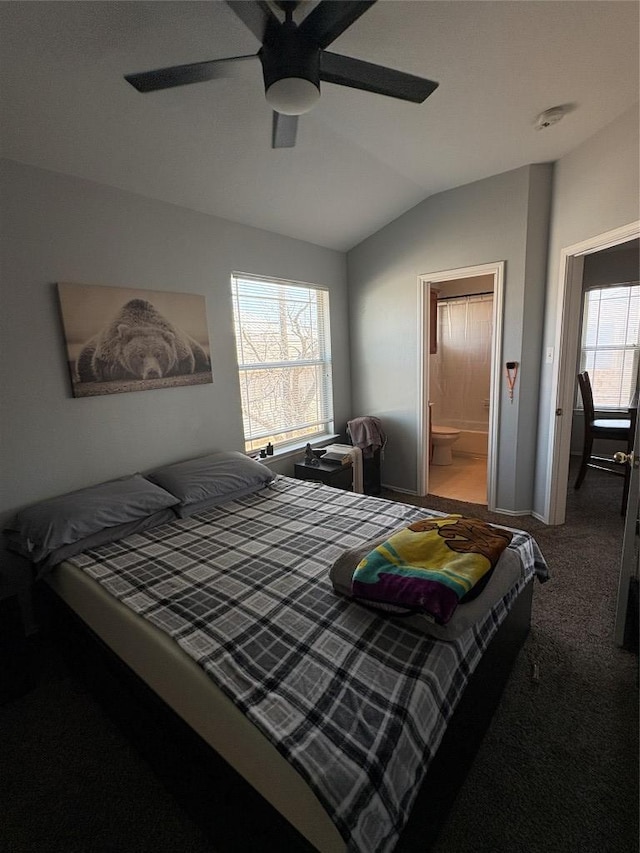 carpeted bedroom with vaulted ceiling, a ceiling fan, and ensuite bathroom