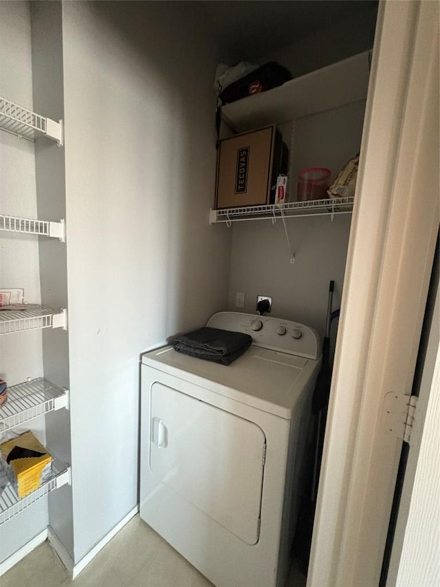 laundry room with laundry area, washer / dryer, and baseboards