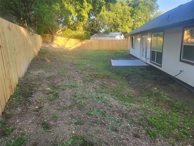 view of yard with french doors and a fenced backyard