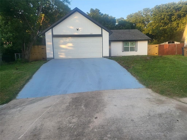 single story home with a front lawn, an attached garage, fence, and driveway