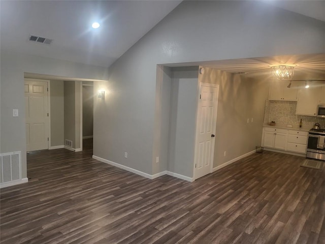 interior space with visible vents, baseboards, dark wood-type flooring, and high vaulted ceiling