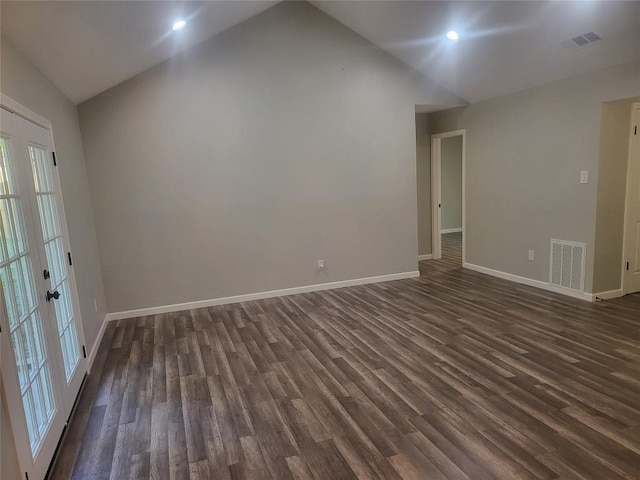 unfurnished room with dark wood-style floors, visible vents, and vaulted ceiling