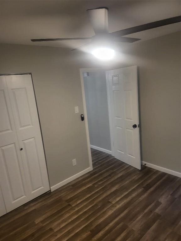 unfurnished room featuring ceiling fan, baseboards, and dark wood finished floors