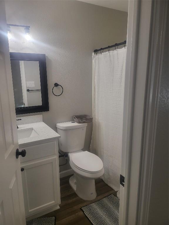 full bathroom with vanity, toilet, and wood finished floors