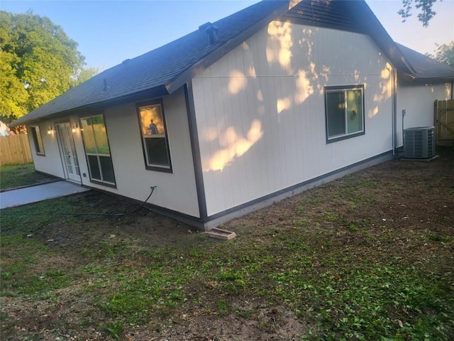 view of side of home with central AC unit, fence, and french doors