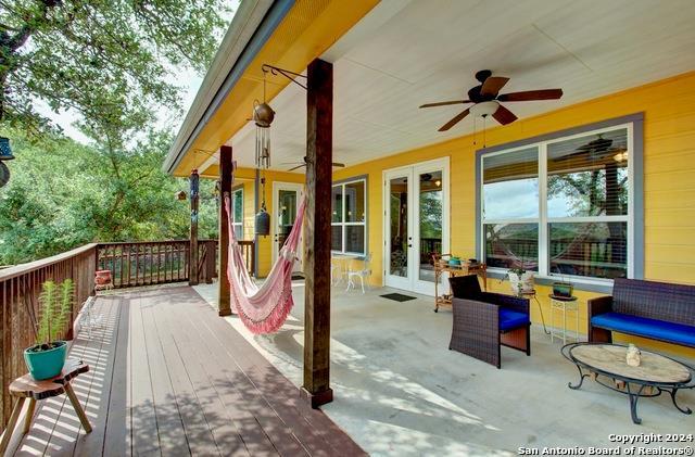 wooden terrace featuring french doors and ceiling fan