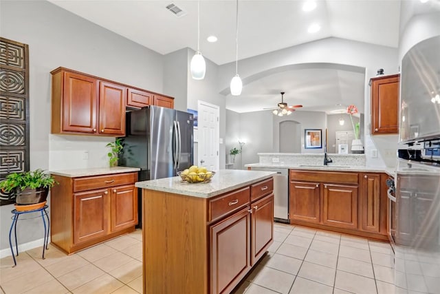 2700 Tumbling River Dr, Leander, TX 78641 - kitchen featuring stainless steel appliances, a ceiling fan, light tile patterned floors, lofted ceiling, and brown cabinets