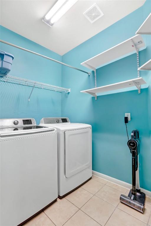 2700 Tumbling River Dr, Leander, TX 78641 - laundry room featuring washing machine and dryer, light tile patterned flooring, and baseboards