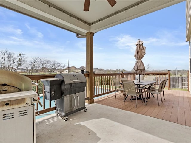 view of patio featuring outdoor dining space, a deck, a ceiling fan, and a grill