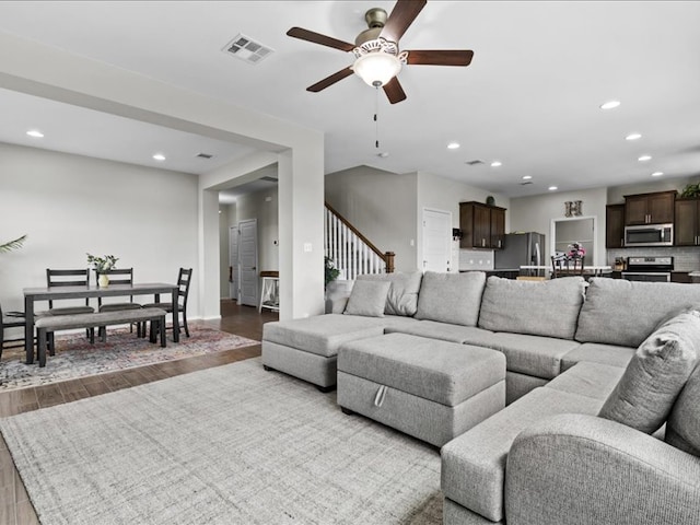 living room with visible vents, wood finished floors, recessed lighting, stairway, and ceiling fan