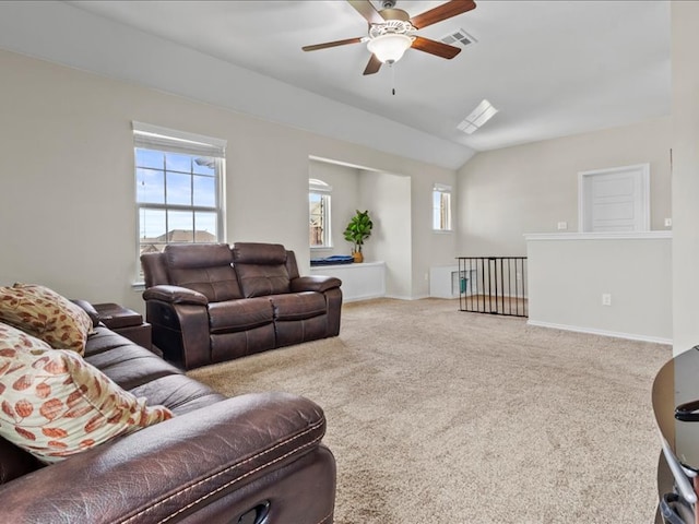 carpeted living room with lofted ceiling, visible vents, baseboards, and ceiling fan