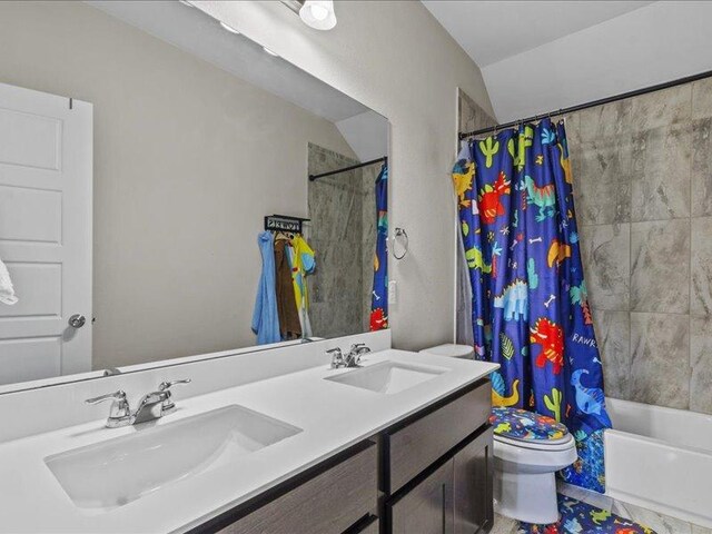 bathroom with double vanity, toilet, shower / bath combo with shower curtain, and a sink