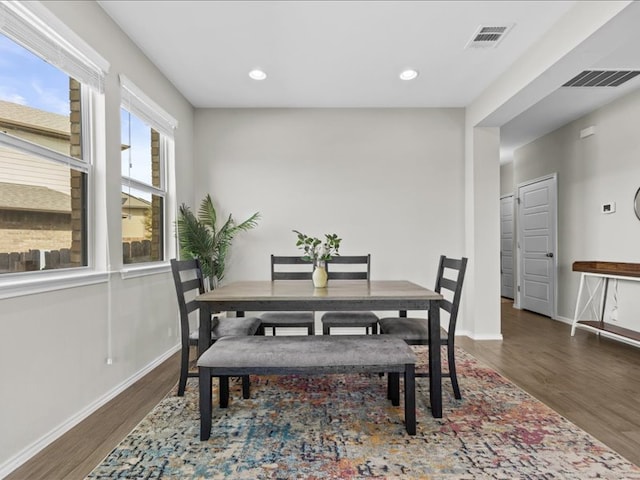 dining area featuring visible vents, baseboards, and wood finished floors