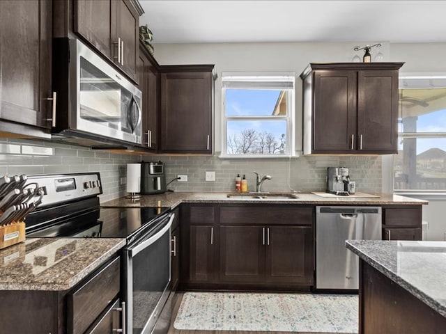 700 Carillion Dr, Pflugerville, TX 78660 - kitchen with a sink, stainless steel appliances, tasteful backsplash, and dark brown cabinetry
