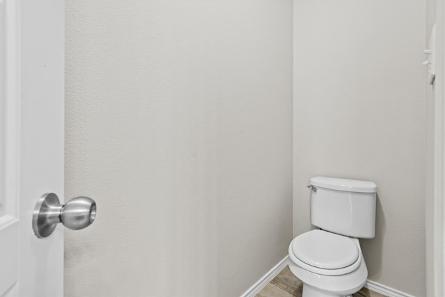 bathroom featuring baseboards and toilet