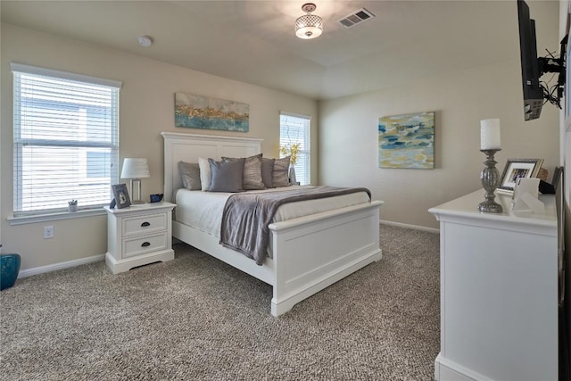 carpeted bedroom with visible vents and baseboards